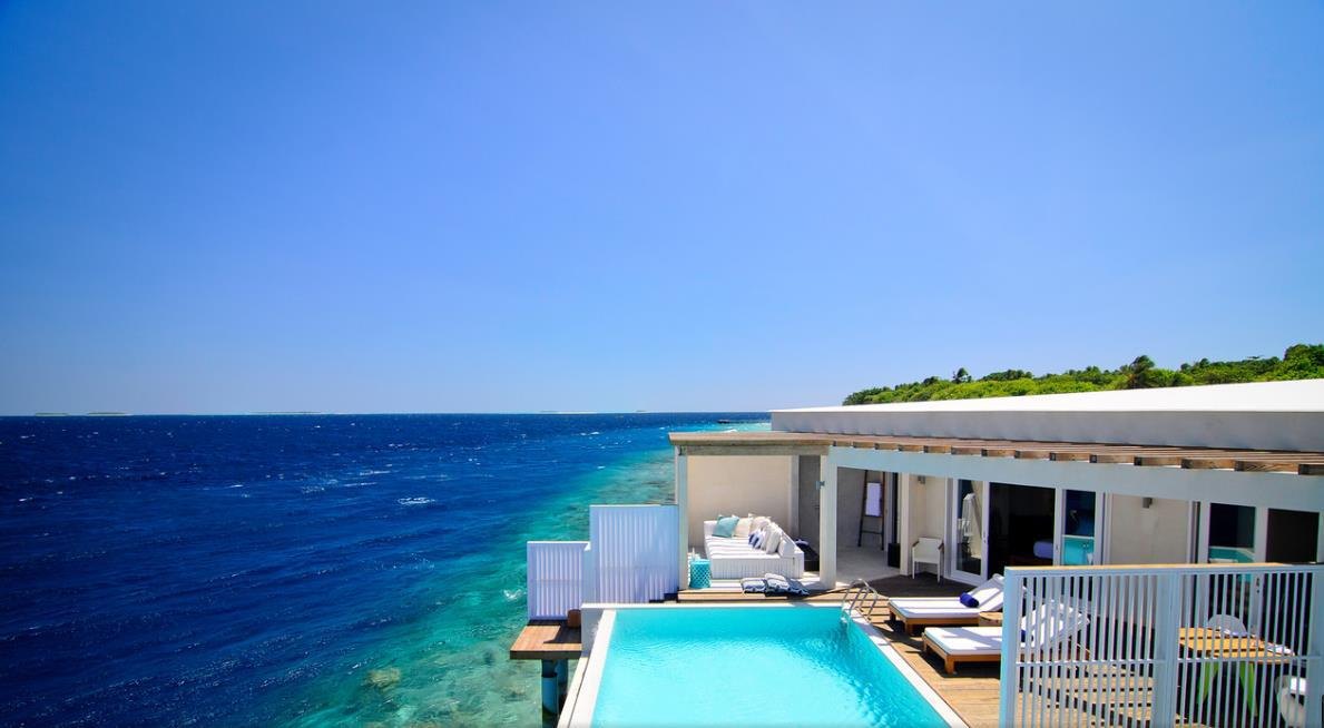 Luxury pool villa beside blue ocean water