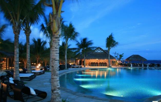 Evening resort pool with timber buildings